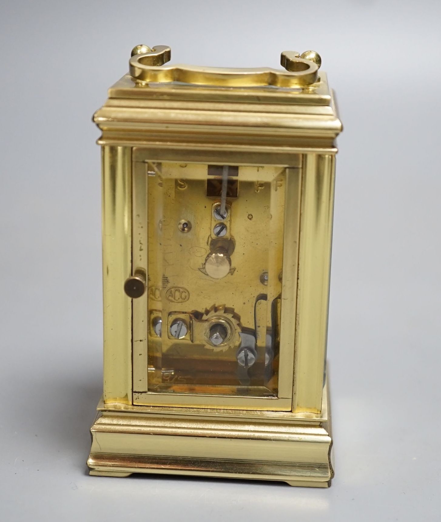 A small brass carriage time piece and key 9cm